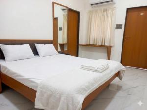 ein Schlafzimmer mit einem Bett, auf dem zwei Handtücher liegen in der Unterkunft Hotel Bliss County in Dhule
