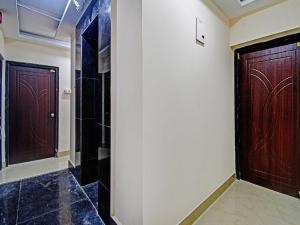 a hallway with two wooden doors in a room at Hotel O ASHIRBAD PALACE in Urāli