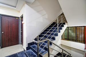 a staircase with blue tiles and a brown door at Hotel O ASHIRBAD PALACE in Urāli