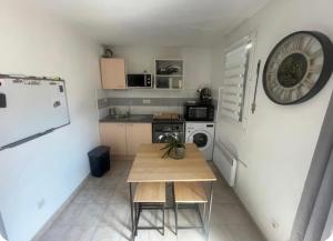 a small kitchen with a table and a refrigerator at Maison avec jardin in Calvisson