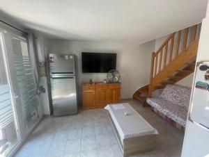 a kitchen with a stainless steel refrigerator and a staircase at Maison avec jardin in Calvisson