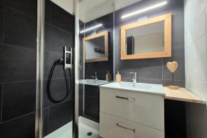 a bathroom with two sinks and a shower with a mirror at Chaleureux studio au pied des pistes - Le refuge in Les Déserts