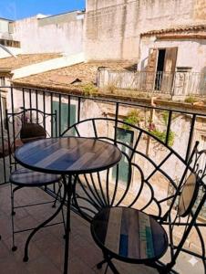 a table and two chairs sitting on a balcony at sciuliddA Casa Vacanze in Avola