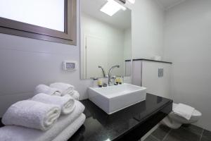a white bathroom with a sink and towels on a counter at מלון ברגר - למגזר החרדי in Tiberias +29 photos