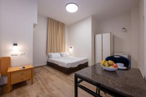 a hotel room with a bed and a bowl of fruit on a table at מלון ברגר - למגזר החרדי in Tiberias