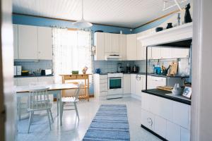 a kitchen with white cabinets and a table and chairs at Faffas in Österretais