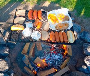 a grill with hot dogs and hamburgers and bread at Pension Fanlor in Zubčická Lhotka