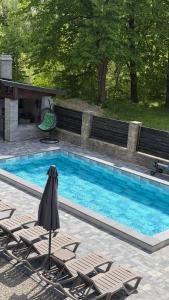 a swimming pool with two lounge chairs next to it at Arkan in Mykulychyn