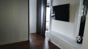 a living room with a flat screen tv on a wall at Ruby Apartment #34 in Yogyakarta