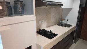 a kitchen counter with a sink and a stove at Ruby Apartment #34 in Yogyakarta +4 photos