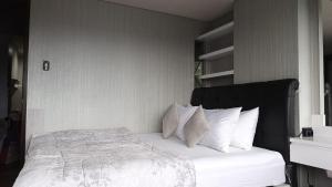 a bedroom with a bed with white sheets and pillows at Ruby Apartment #34 in Yogyakarta