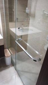 a bathroom with a glass shower with a sink at Ruby Apartment #34 in Yogyakarta