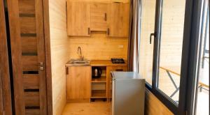 a small kitchen with wooden cabinets and a sink at Tsovazard Lake House in Tsovazard