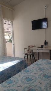 a bedroom with two beds and a table and a tv at Erdek Özlem pansiyon in Erdek