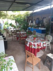 a patio with tables and chairs and a table with a table cloth at Erdek Özlem pansiyon in Erdek