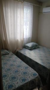 two beds in a room with a window at Erdek Özlem pansiyon in Erdek