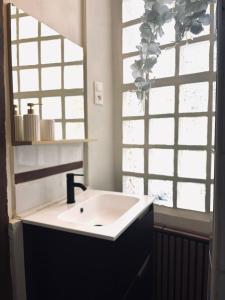 a bathroom with a sink and a mirror at La Suite Archevêché by Collection Signature - Hypercentre Albi - Parking inclus in Albi