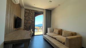 a living room with a couch and a large window at Panoramic Konaklama Tesisi Bodrum in Bodrum City