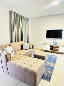 a living room with a couch and a flat screen tv at Elusive Haven in Nelspruit