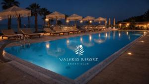 a swimming pool at a resort at night at Valerio Resort beach club in Margherita di Savoia