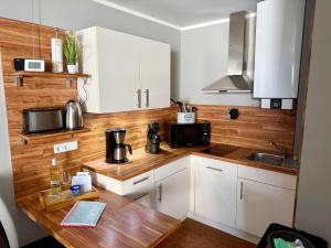 a kitchen with white cabinets and a wooden counter top at Atlantic 209 in Döse
