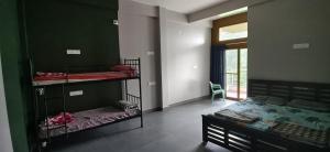 a bedroom with two bunk beds and a window at Belmonte in Kalasa