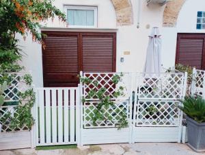 a white fence with a gate in front of a house at La Vecchia Stalla in Palermo