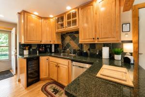 a kitchen with wooden cabinets and a black counter top at Riverwood Lodge in Leavenworth