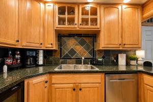 a kitchen with wooden cabinets and a sink at Riverwood Lodge in Leavenworth