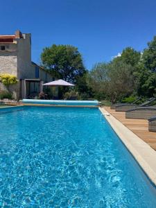 a swimming pool in front of a house at Le pigeonnier in Le Verdier