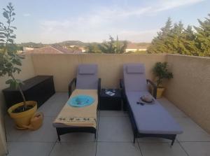 a patio with a table and chairs on a balcony at Suite parentale avec terrasse solarium in Saint-André-de-Roquelongue