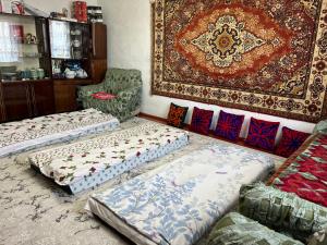 a living room with two beds and a rug at Sunrise Panorama in Bokonbayevo