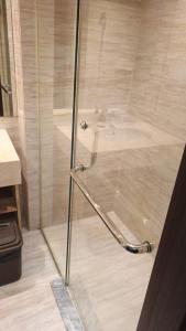 a shower with a glass door in a bathroom at Ruby Apartment #47 in Kejayan