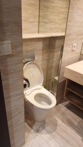 a bathroom with a white toilet in a room at Ruby Apartment #47 in Kejayan +3 photos