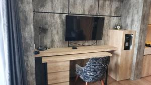 a desk with a television and a chair in a room at Ruby Apartment #47 in Kejayan