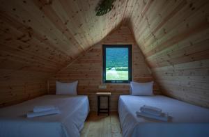 two beds in a wooden room with a window at Moretoni Lake Resort in Napareuli +41 photos