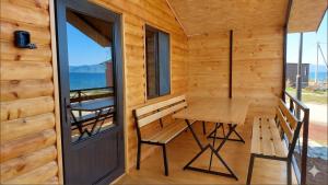 eine Holzhütte mit Tisch und Bank auf dem Balkon in der Unterkunft Sevan - Tsovazard Wooden House in Tsovazard