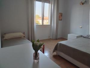 a bedroom with two beds and a vase on a table at Scer GEA in Cerro Maggiore