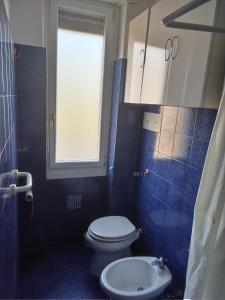 a bathroom with a toilet and a window and a sink at Scer GEA in Cerro Maggiore
