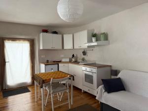 a small kitchen with a table and a couch at Le Châtaignier in Faveyrolles +23 photos