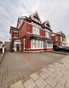 a large red brick building on a brick street at Avenue Guest House in Blackpool