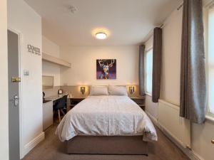 a bedroom with a bed and a desk in it at Avenue Guest House in Blackpool