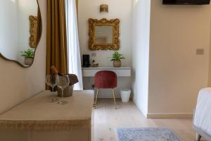 a living room with a mirror and a red chair at Casa GenaRita in Ravenna