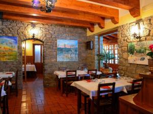a restaurant with tables and chairs and a stone wall at Hotel Da Giovanna in Chiusi della Verna