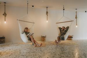 two people sitting in hammocks in a room at Hotel Seehof Nature Retreat in Natz-Schabs