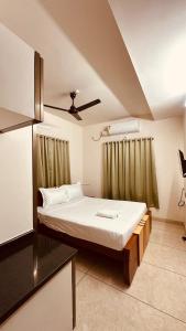a bedroom with a bed with a ceiling fan at Blanco Airport Suite in Kāladi