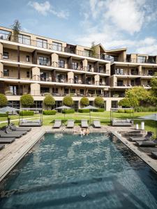 a hotel with a pool in front of a building at Hotel Seehof Nature Retreat in Natz-Schabs
