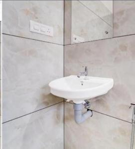 a white bathroom with a sink and a mirror at Blanco Airport Suite in Kāladi