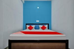 a bedroom with a bed with red and blue walls at Hotel O My Choice in Indore +16 photos