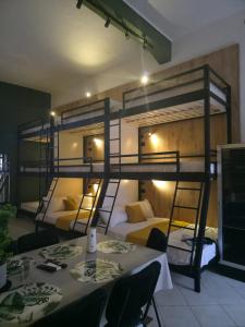 two bunk beds in a room with tables and chairs at City Center Hostel Durres in Durrës